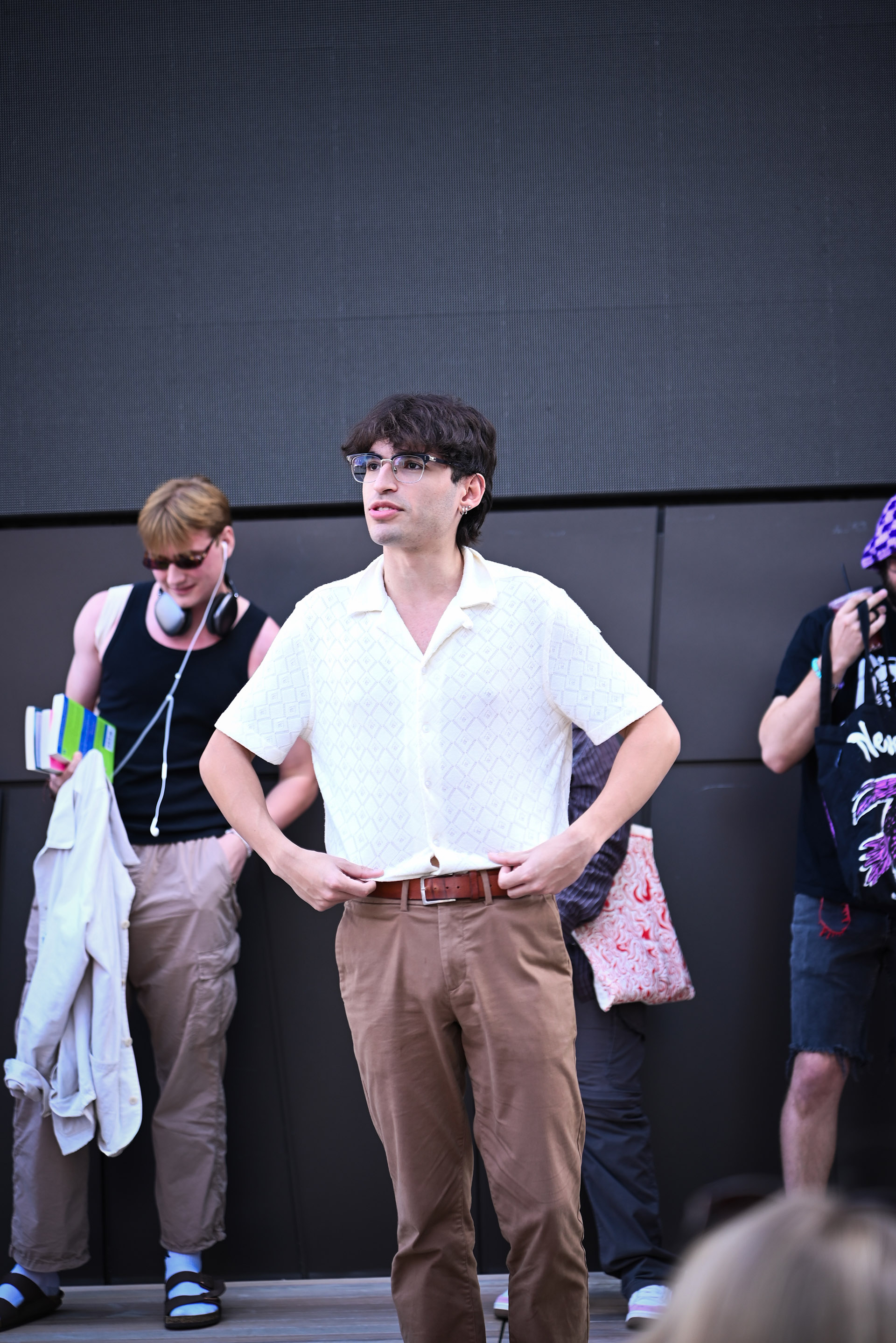 Photo of a young man with glasses in white shirt and brown pants.