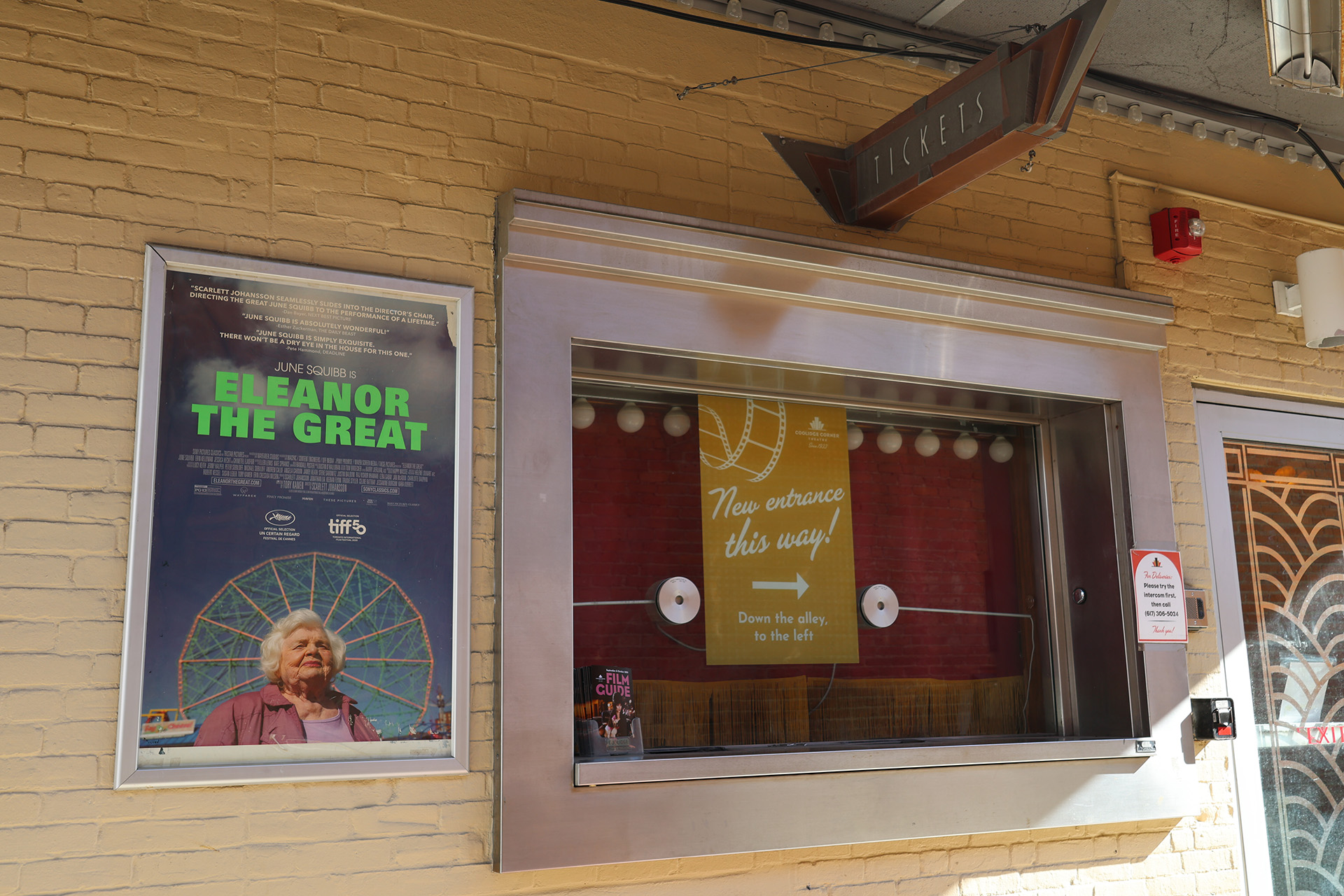 Photo of an old ticket both with a sign that says new entrance this way!