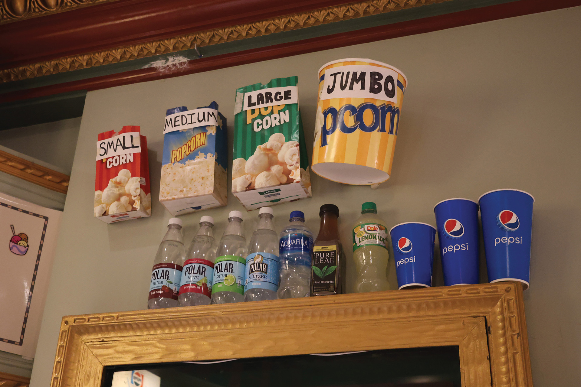 Close-up photo of the popcorn and drink sizes, as well as other drink options at the Somerville Theater