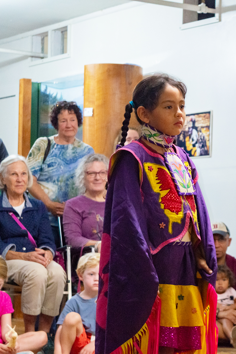 One of Greendeer's daughters stares ahead with a crowd watching her from behind.